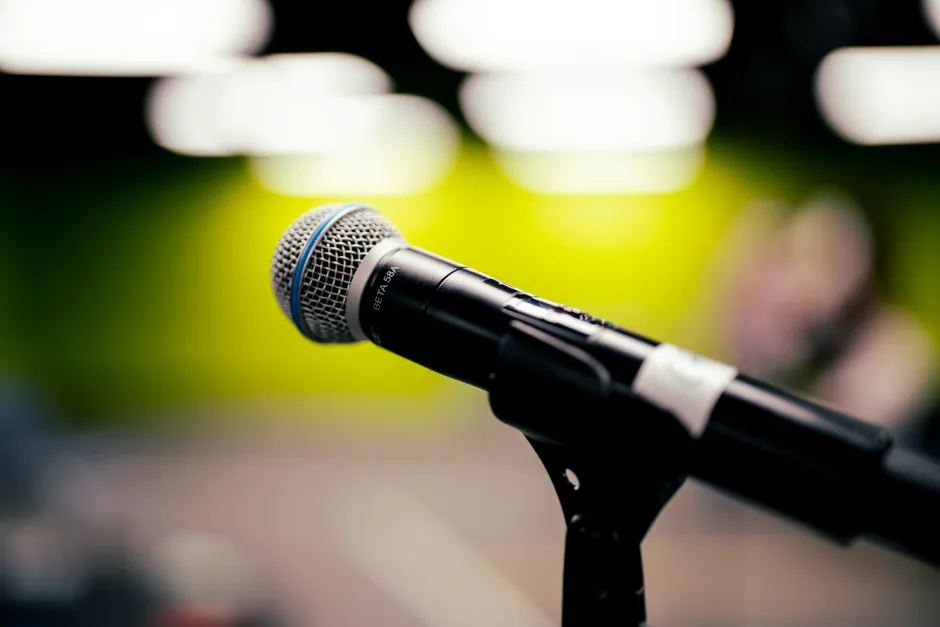 A detailed shot of a microphone on stage, perfect for audio and music themes.