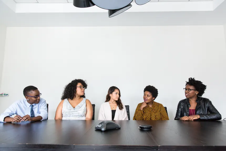 A diverse group of professionals having a meeting in a modern office setting. Teamwork and collaboration.
