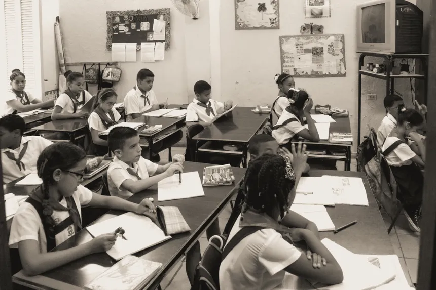 A classroom of attentive school children studying at their desks in uniform.
