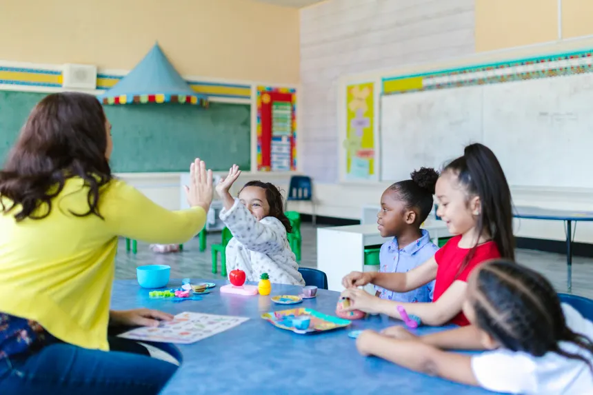 A joyful classroom scene with a teacher and diverse group of children engaging in playful learning activities.
