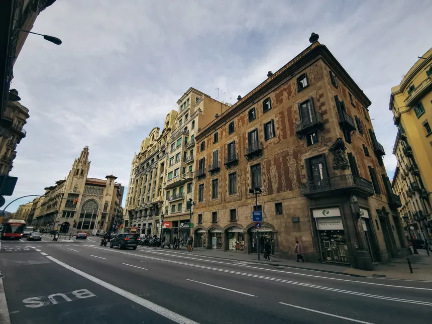 View of a historic street featuring classic European architecture and bustling city life.