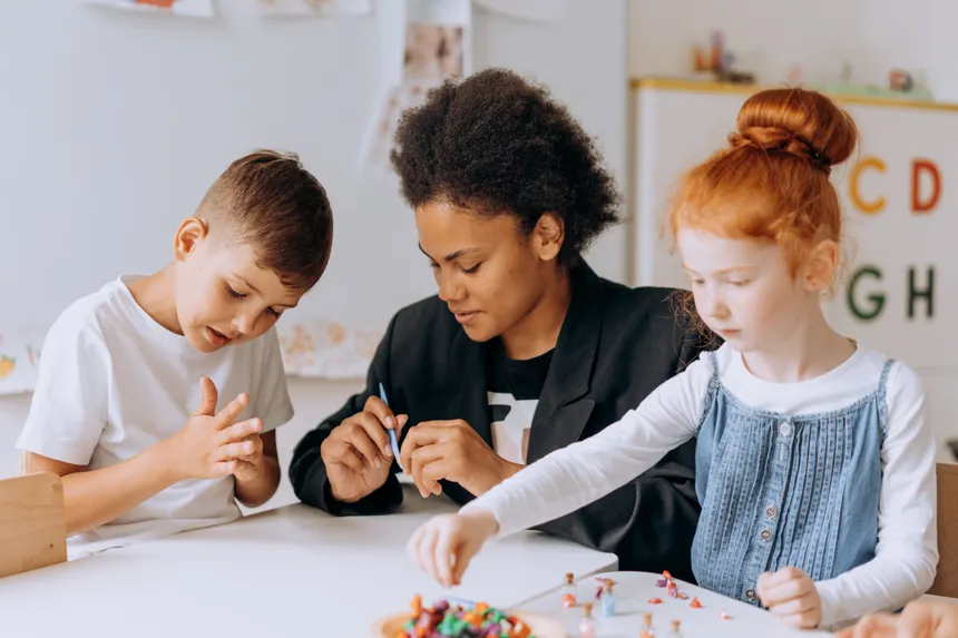 Teacher engaging with children in a classroom setting, fostering learning and creativity.