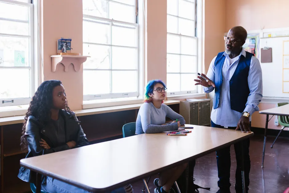 A teacher engaging with students in a classroom setting, promoting open communication.